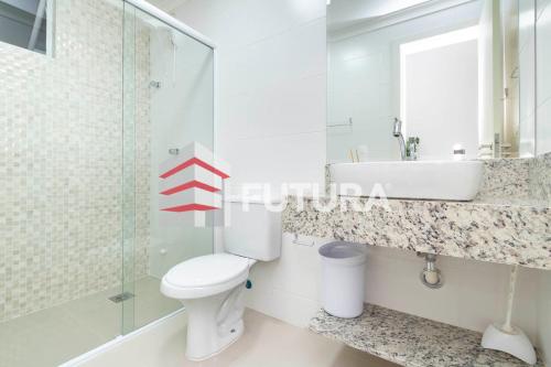 a bathroom with a toilet and a sink and a mirror at LA018E - Apartamento na Praia in Bombinhas