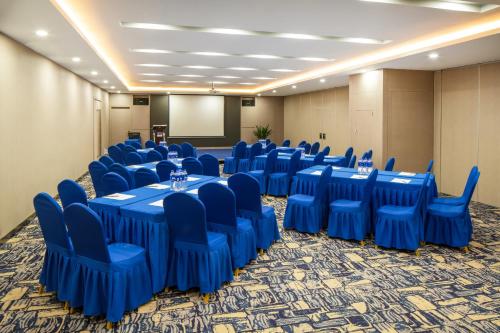 a conference room with blue tables and chairs and a screen at Holiday Inn Express Shenyang North Station by IHG in Shenyang