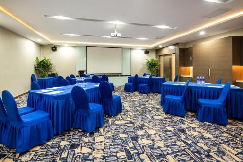 a conference room with blue tables and chairs and a screen at Holiday Inn Express Shenyang North Station by IHG in Shenyang