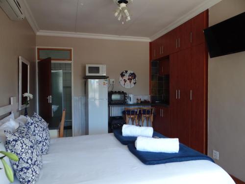 a kitchen with a large bed with blue and white pillows at CREDO Guest House in Bloemfontein