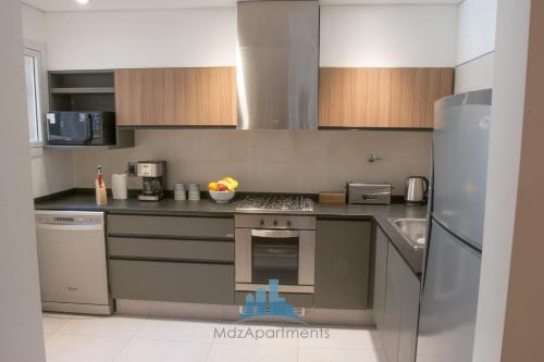 uma cozinha com utensílios de aço inoxidável e armários de madeira em Mdz Apartments III em Mendoza
