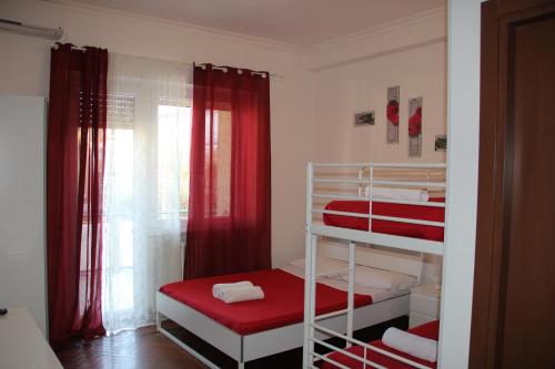 a small room with two bunk beds with red curtains at Domus Vatican Holiday's in Rome