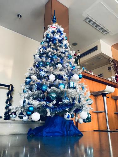 a christmas tree with blue and white ornaments on it at Hotel San Carlo in Mestre