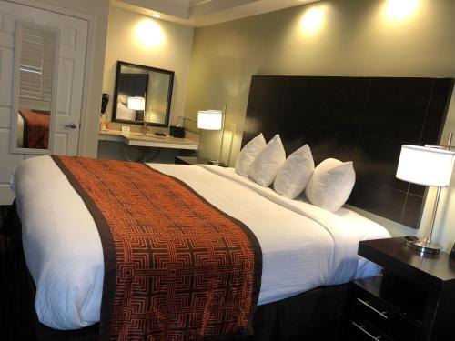 a hotel room with a large bed with white sheets and pillows at Seaside Inn in San Francisco