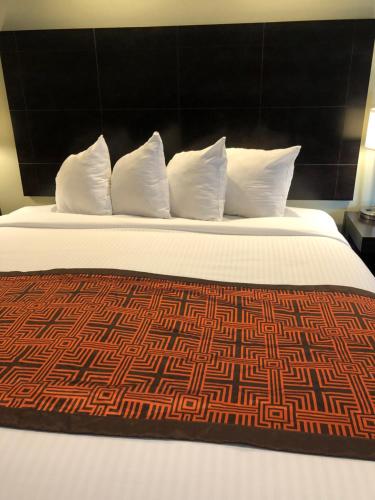 uma cama grande com almofadas brancas e um cobertor castanho em Seaside Inn em São Francisco