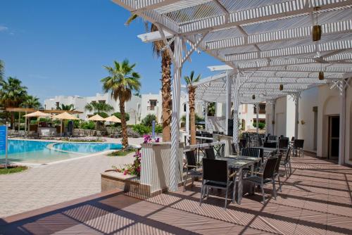 a patio with tables and chairs next to a pool at Amphoras Aqua in Sharm El Sheikh