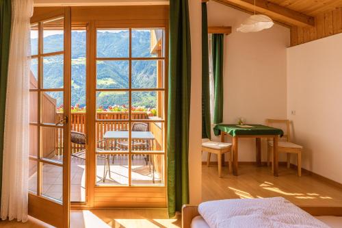 a bedroom with a view of a balcony at Gasthof Falkenstein in Naturno