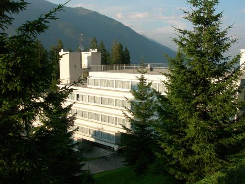 a large white building with a mountain in the background at Appartamenti Vacanze Casa -Residence Albare - check in Vacanze Casa - Marilleva 900 in Marilleva