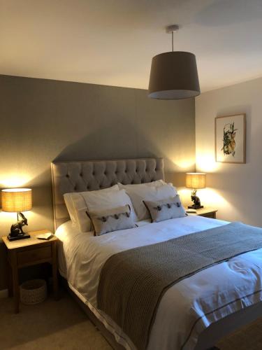 - une chambre avec un grand lit blanc et deux lampes dans l'établissement Bradan, à Pitlochry
