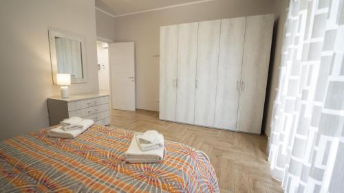 Appartamento Campanella في ايزولا كابو ريزوتو: غرفة نوم عليها سرير وفوط