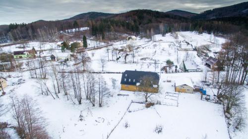 un pequeño pueblo cubierto de nieve con casas en Penzion PIŠLIKDUM, en Stará Červená Voda