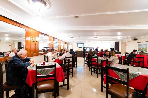 a group of people sitting at tables in a restaurant at Hotel Virrey Central in Bogotá