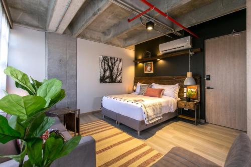 a bedroom with a bed and a tv on a wall at Factory Lofts Hotel in Medellín