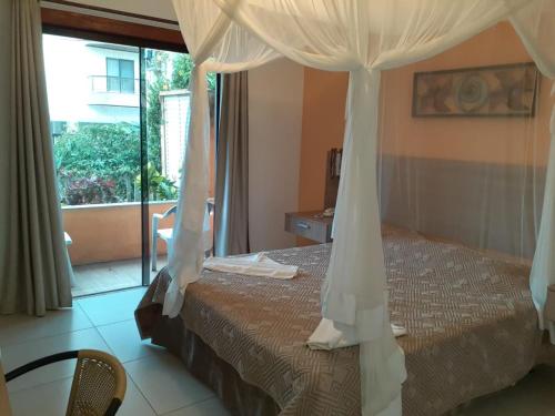 1 dormitorio con 1 cama con dosel en Hotel La Brise, en Cabo Frío