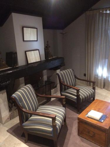 a living room with two chairs and a piano at Hotel Palacio de Mengibar in Mengibar