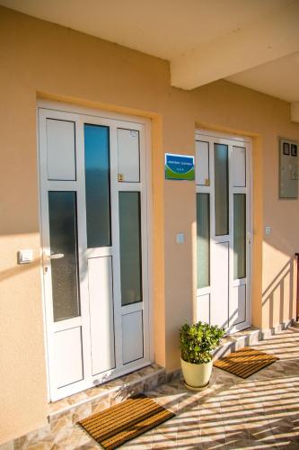 two doors on a building with a potted plant at Studio apartmani Milović in Trebinje