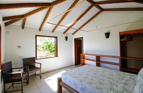 Fazenda Eco-Jardim في Una: غرفة نوم بسرير وكرسي ونافذة