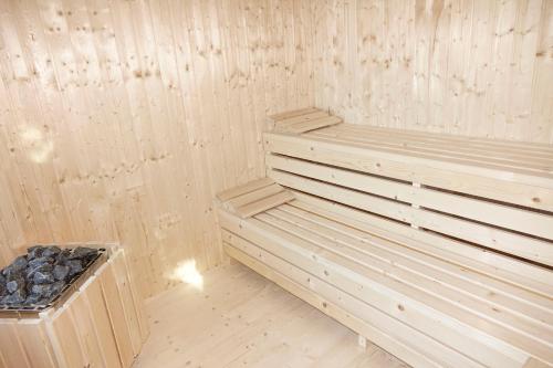 a wooden sauna with a bench in a room at Haus Alpengluehn in Iselsberg