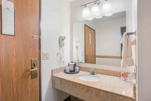 a bathroom with a sink and a mirror at Econo Lodge Cedar Rapids South in Cedar Rapids