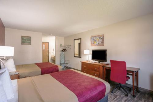 a hotel room with two beds and a desk with a computer at Econo Lodge in Cedar Rapids