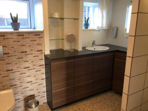 uma casa de banho com um lavatório e um espelho em Skagentoppen Rooms em Skagen