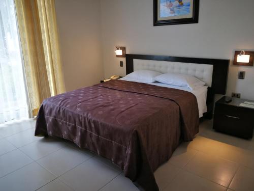 1 dormitorio con 1 cama grande con manta marrón en Caballito de Totora, en Huanchaco