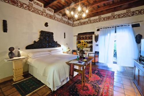 - une chambre avec un grand lit et une table dans l'établissement Casa de la Real Aduana Boutique Hotel, à Pátzcuaro