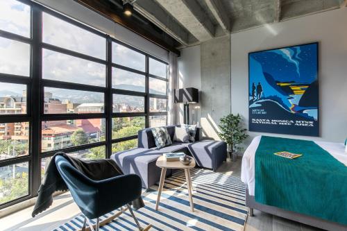 a bedroom with a bed and a large window at Factory Lofts Hotel in Medellín