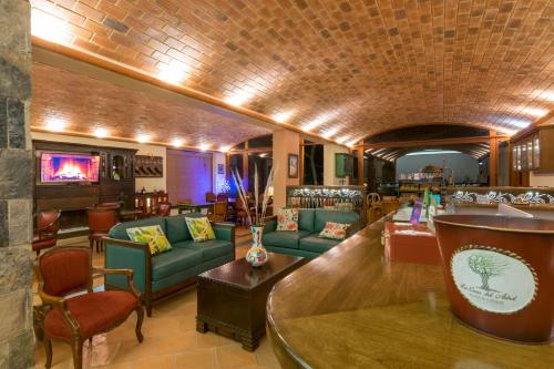 a lobby with couches and chairs and a bar at La Casa Del Arbol Hotel Boutique Villa de Leyva in Villa de Leyva