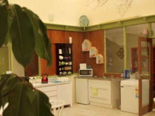 a kitchen with white cabinets and a microwave at Waimoana Garden Accommodation in Whangarei