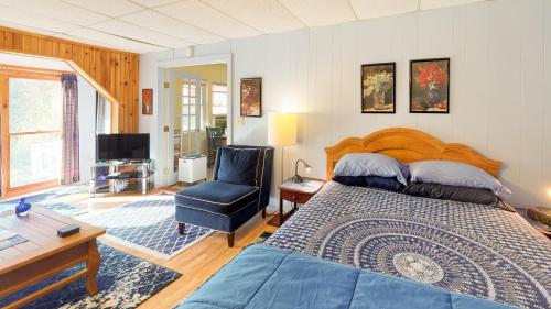 1 dormitorio con cama, escritorio y silla en Cavalier Cottage B&B en Shelburne Falls