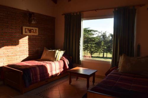 1 dormitorio con cama, ventana y sofá en Complejo Yantes en Villa Giardino