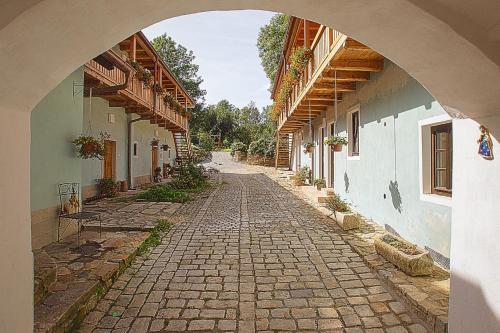 an alley with an archway between two buildings at U Svatého Petra in Kájov