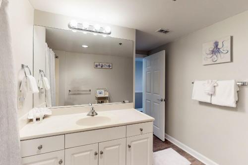 a bathroom with a sink and a large mirror at Sterling Shores in Destin