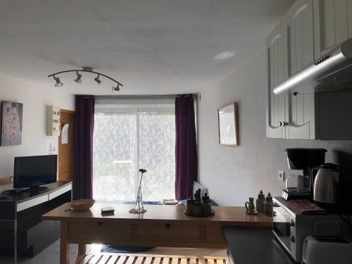 a kitchen with a wooden table in front of a window at Gite Augirons in Saint-Ciers-sur-Gironde