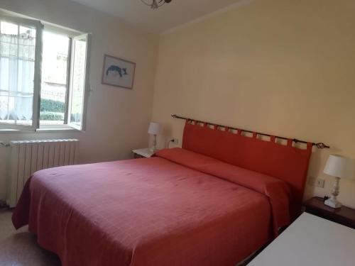 1 dormitorio con cama roja y ventana en A due passi dal Gran Sasso, en Fano a Corno