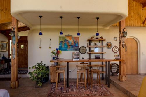 a kitchen with a large wooden table and stools at Parcela Olmué La Luz in Olmué