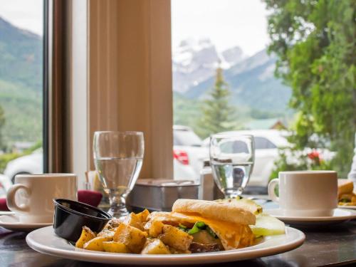 a table with a plate of food and wine glasses at Park Place Lodge in Fernie