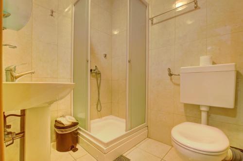 a bathroom with a shower and a toilet and a sink at Hotel Snješko in Jahorina