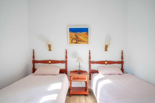 a bedroom with two beds and a nightstand between them at La "Casita" de la Sierra in Guadarrama