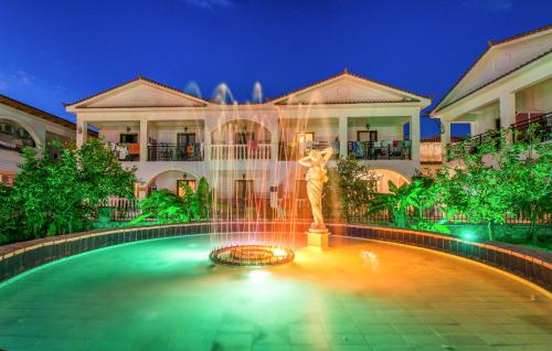 a fountain in front of a large building at Canadian Hotel in Laganas