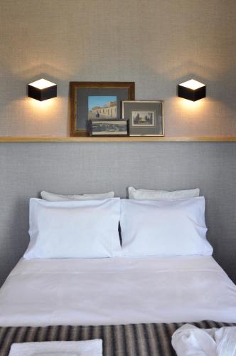 a bed in a hotel room with two pictures on the wall at Apartment by the Sea in Porto