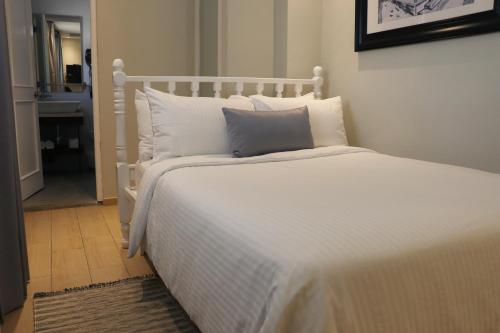 a white bed with white pillows in a bedroom at Hotel Conde de Penalba in Santo Domingo
