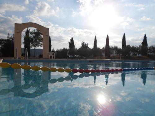 a swimming pool with the sun reflecting in the water at Hotel Vega Perugia in Perugia