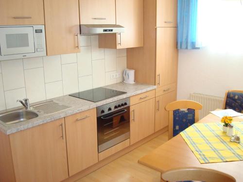 a kitchen with a sink and a stove top oven at Sport Garni Kapplerhof – Ischgl/Kappl in Kappl