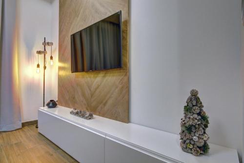 a christmas tree sitting on a white shelf with a television at Apartment A17 LUX in Jahorina