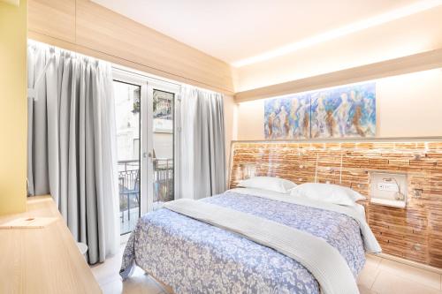 - une chambre avec un lit et un mur en briques dans l'établissement Acropolis Suites - Where else in Athens?, à Athènes