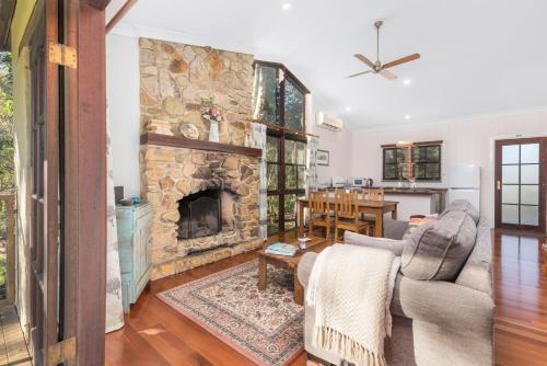 a living room with a stone fireplace at Friday Creek Retreat in Coffs Harbour