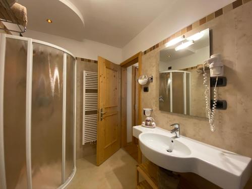 a bathroom with a sink and a shower at Boutique Hotel Diana in Madonna di Campiglio