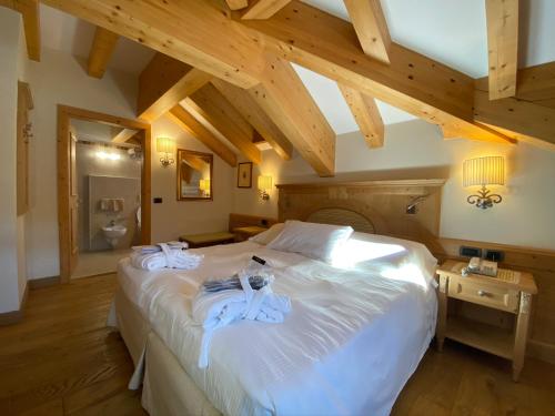 a bedroom with a large bed with towels on it at Boutique Hotel Diana in Madonna di Campiglio